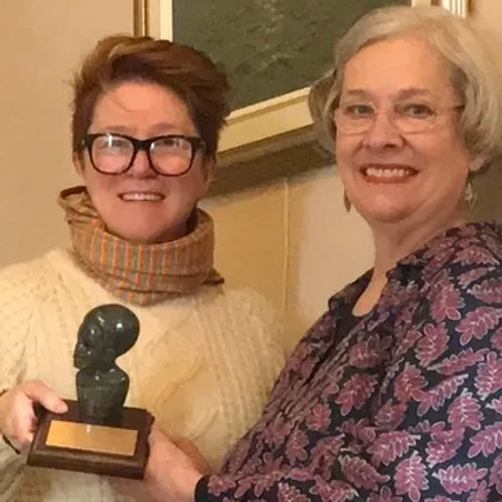 Martha presents Cynthia  with a sculpture in appreciation